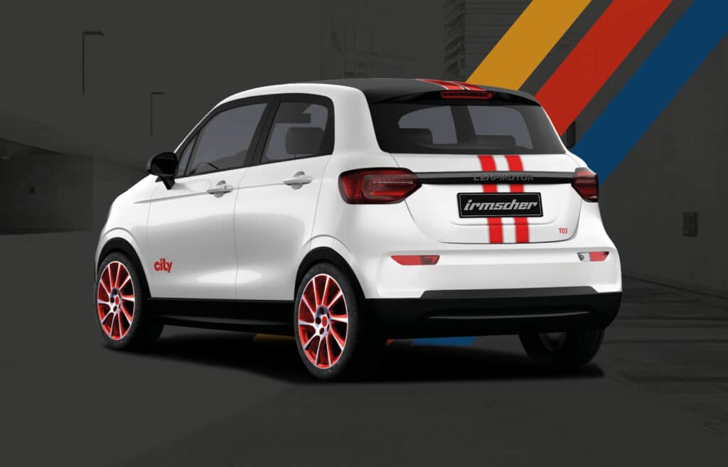 Auf diesem Bild ist ein weißer Leapmotor T03 in einer Irmscher-Edition mit roten Rennstreifen, dem Schriftzug 'city' auf der Seite und roten Felgen vor einem urbanen Hintergrund zu sehen.